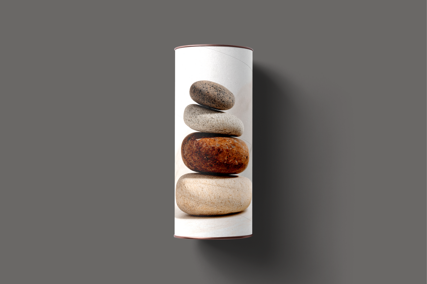 cylindrical product packaging with stacked stones design on a gray background