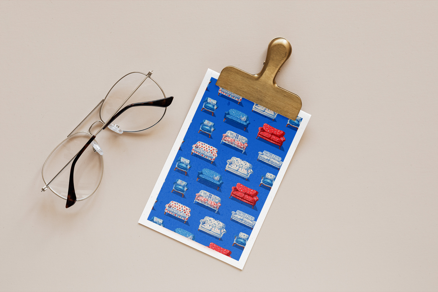 Eyeglasses next to a clip with a colorful product sheet on a beige background