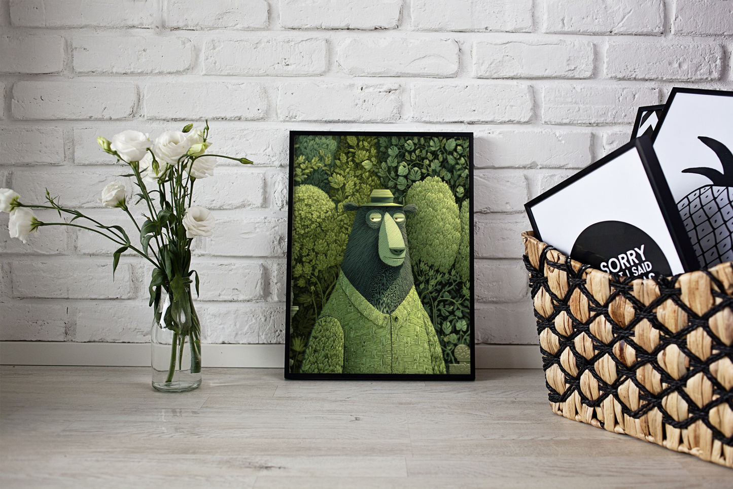 Framed artwork of a green bear on a white brick wall with a vase of flowers and a basket of books.