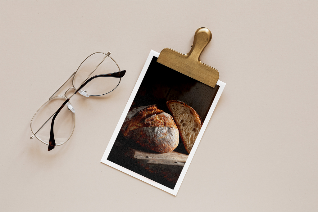 Polaroid photo of bread on a beige surface with eyeglasses