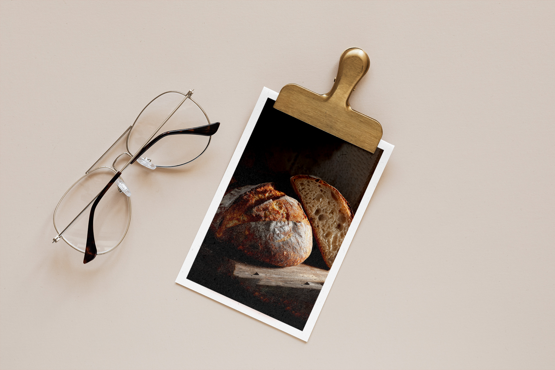 Polaroid photo of bread on a beige surface with eyeglasses