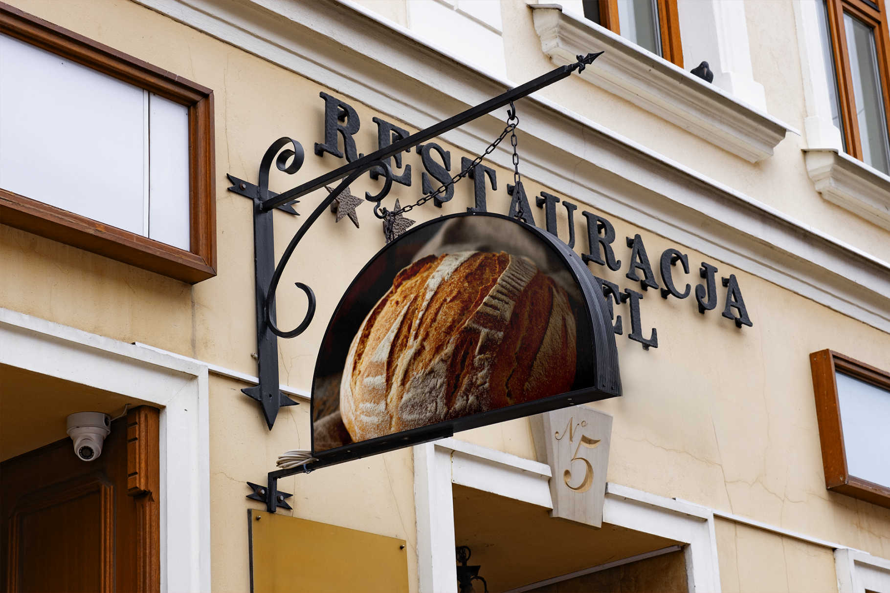 Restaurant sign with bread image and 'RESTAURACJA' text on a building facade.