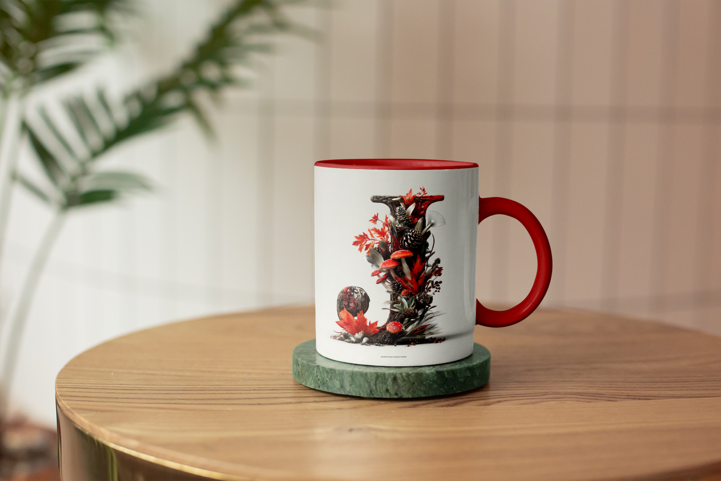 Mug with a red handle on a wooden table, featuring a design of flowers and leaves.