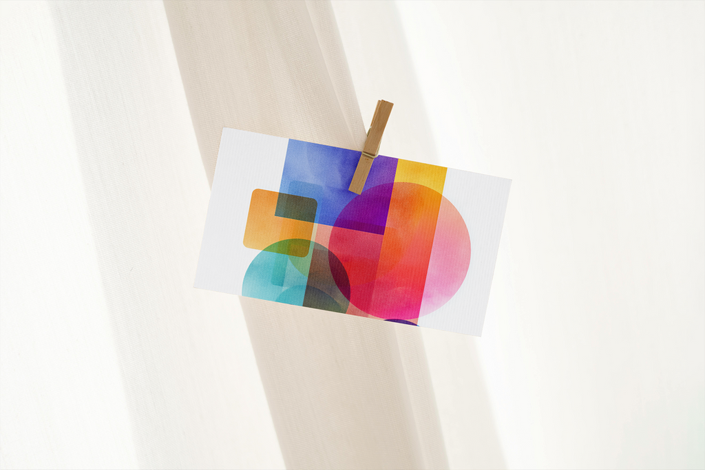 Colorful abstract design on a white napkin held by a wooden fork against a white background
