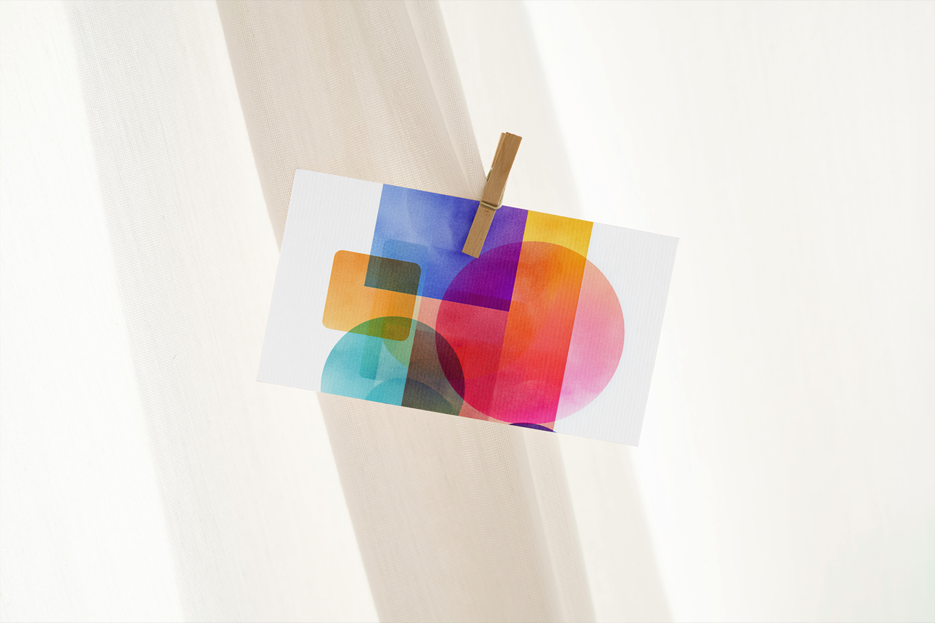 Colorful abstract design on a white napkin held by a wooden fork against a white background