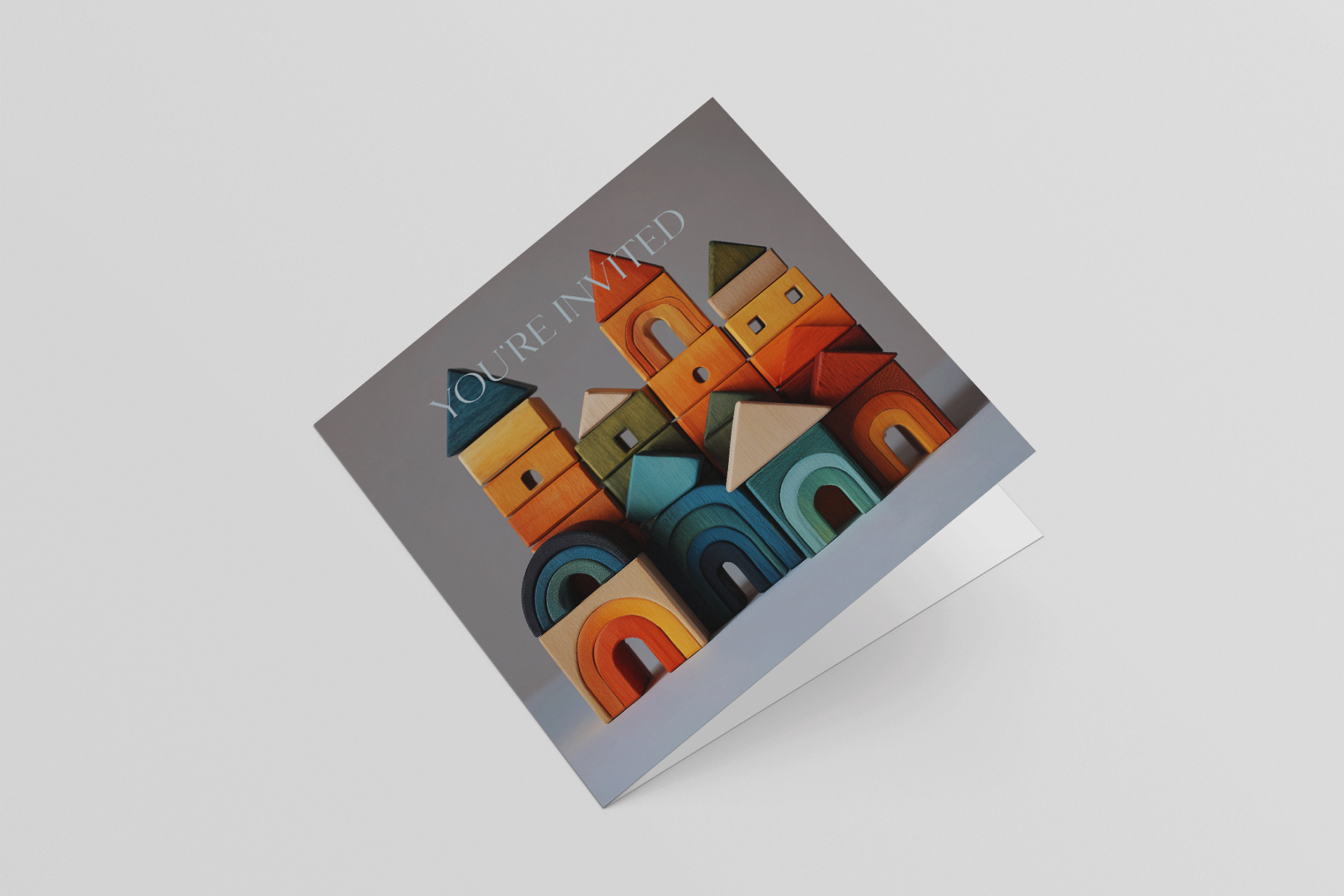 Colorful paper sculpture of a town in a box on a light gray background