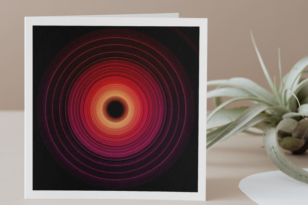 Framed abstract art with concentric circles on a table with a plant