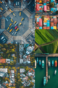 Collage of aerial views including a city intersection, colorful buildings, green fields, and a dock with boats.