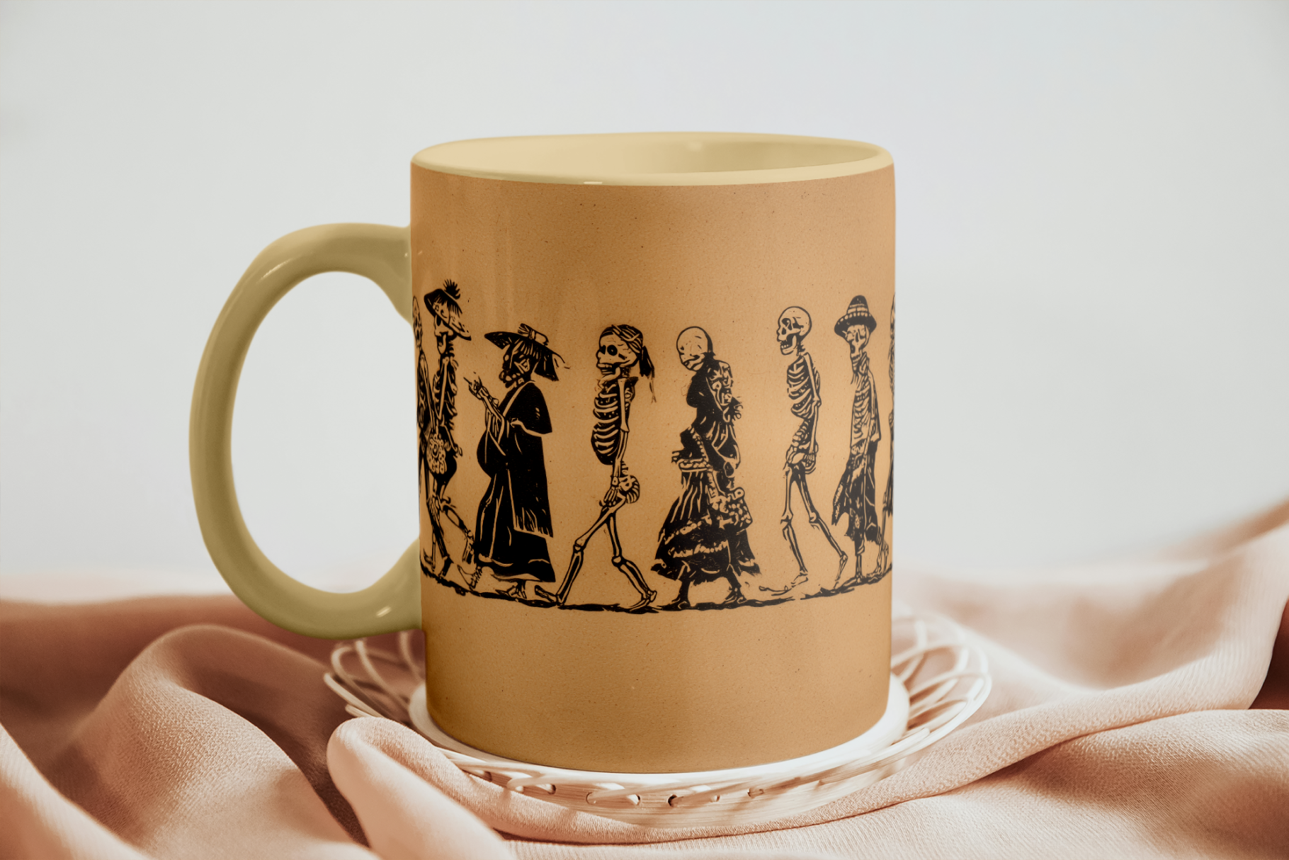 Beige mug with black silhouette designs of people on a beige surface
