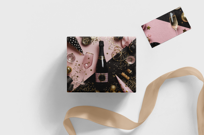 Gift box with champagne and pink accents on a white background