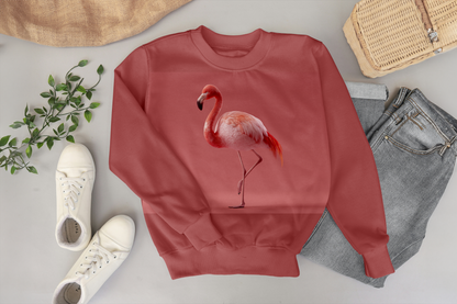 Red sweatshirt with a flamingo design on a light gray surface with shoes, jeans, and a basket.