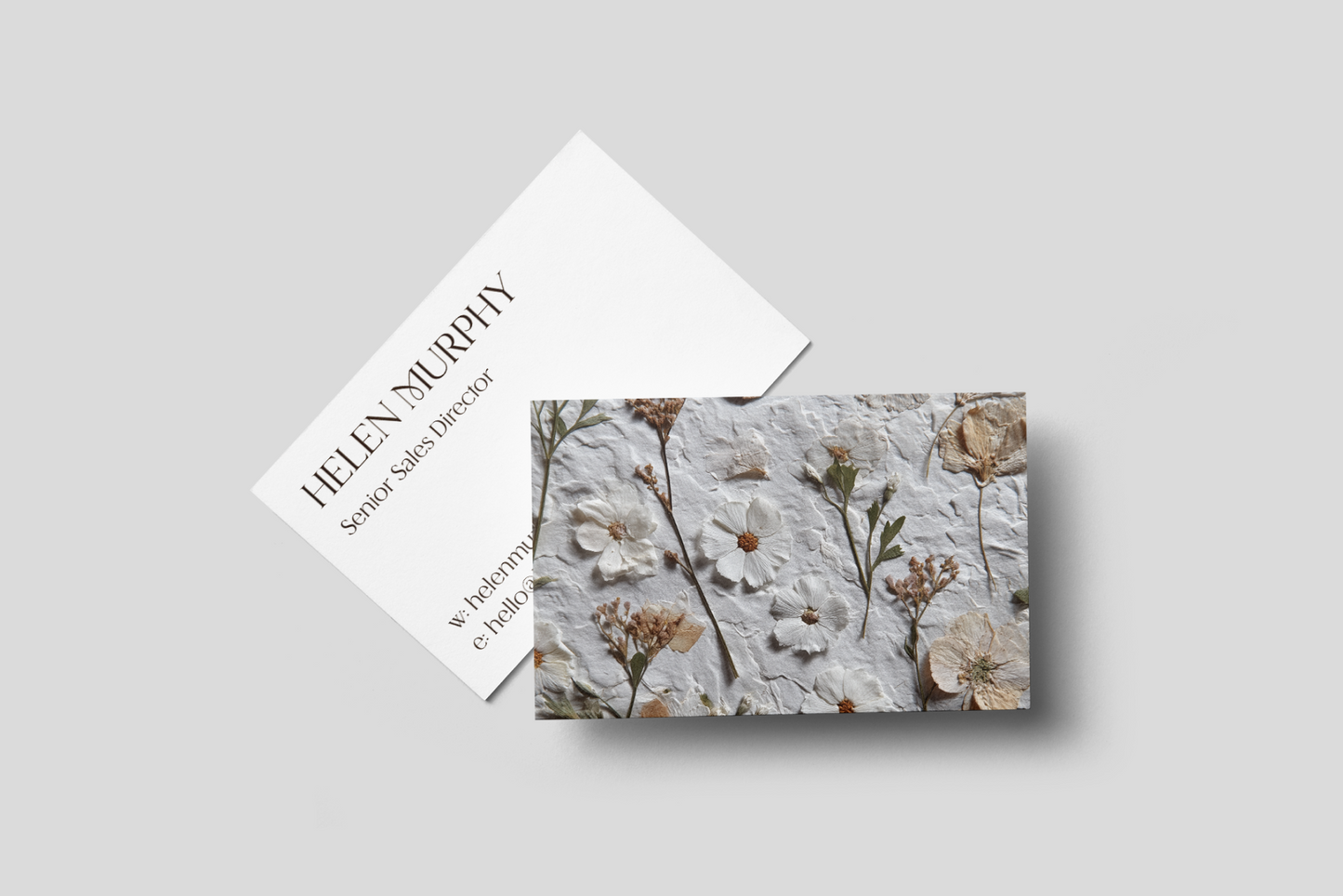 Business card with floral design and text on a gray background