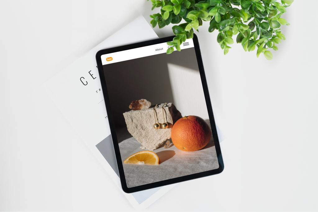 Tablet displaying a product image on a white surface with a plant in the background