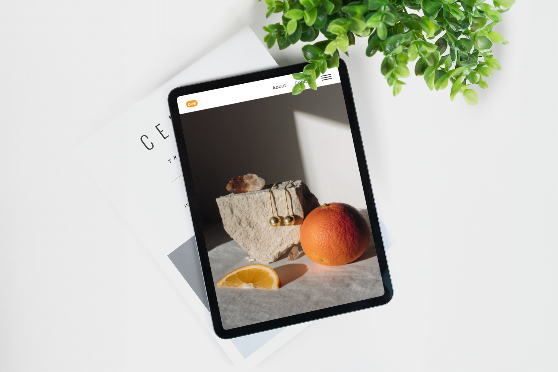 Tablet displaying a product image on a white surface with a plant in the background
