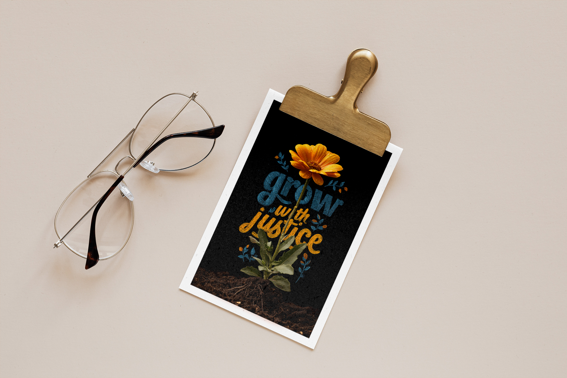 Clipboard with a motivational poster featuring a flower and text 'grow with justice' on a beige background, accompanied by eyeglasses.