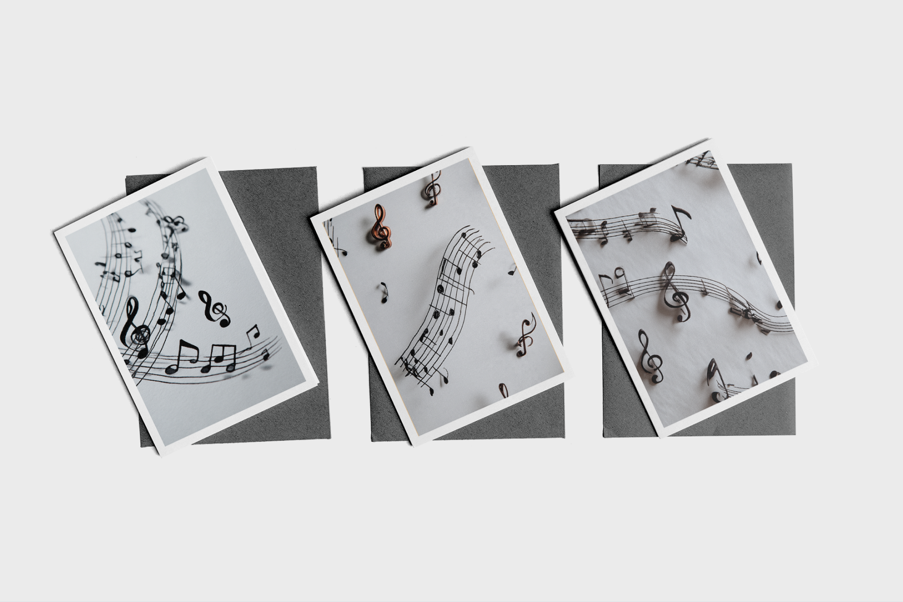 Three cards with music notes on a gray background