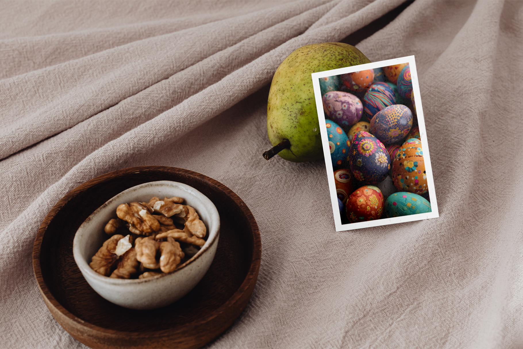 Bowl of nuts on a wooden plate with a pear and colorful Easter eggs on a beige fabric background