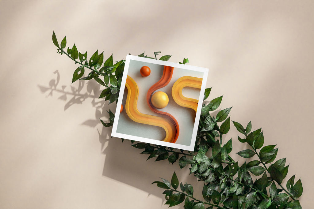 Framed artwork with abstract design of wavy lines and spheres, surrounded by green leaves on a beige background.