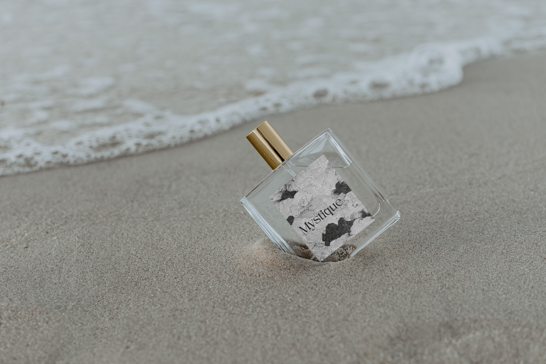 Perfume bottle on a sandy beach with ocean waves in the background