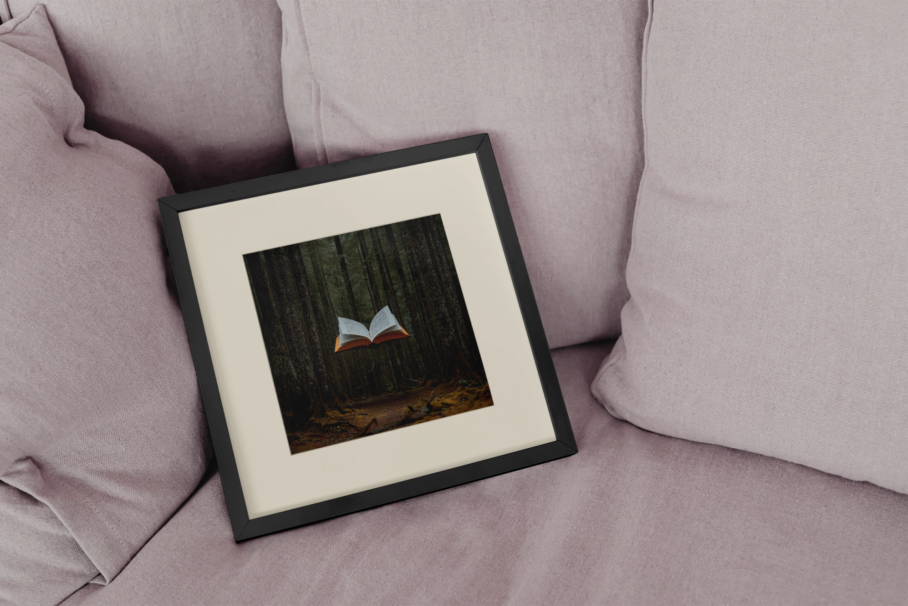 Framed artwork of a book in a forest on a pink couch