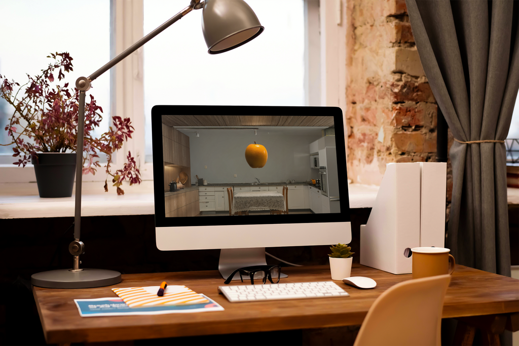 Home office desk with computer monitor, keyboard, and decorative items.