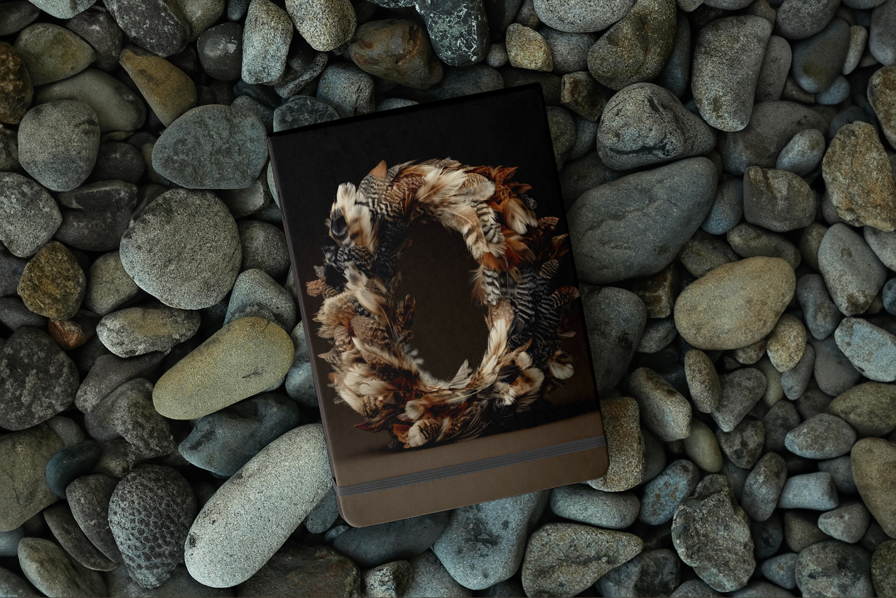 Notebook with a nature-themed cover on pebbles