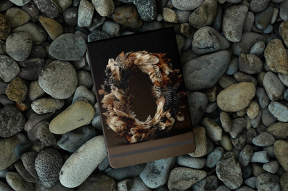 Notebook with a nature-themed cover on pebbles