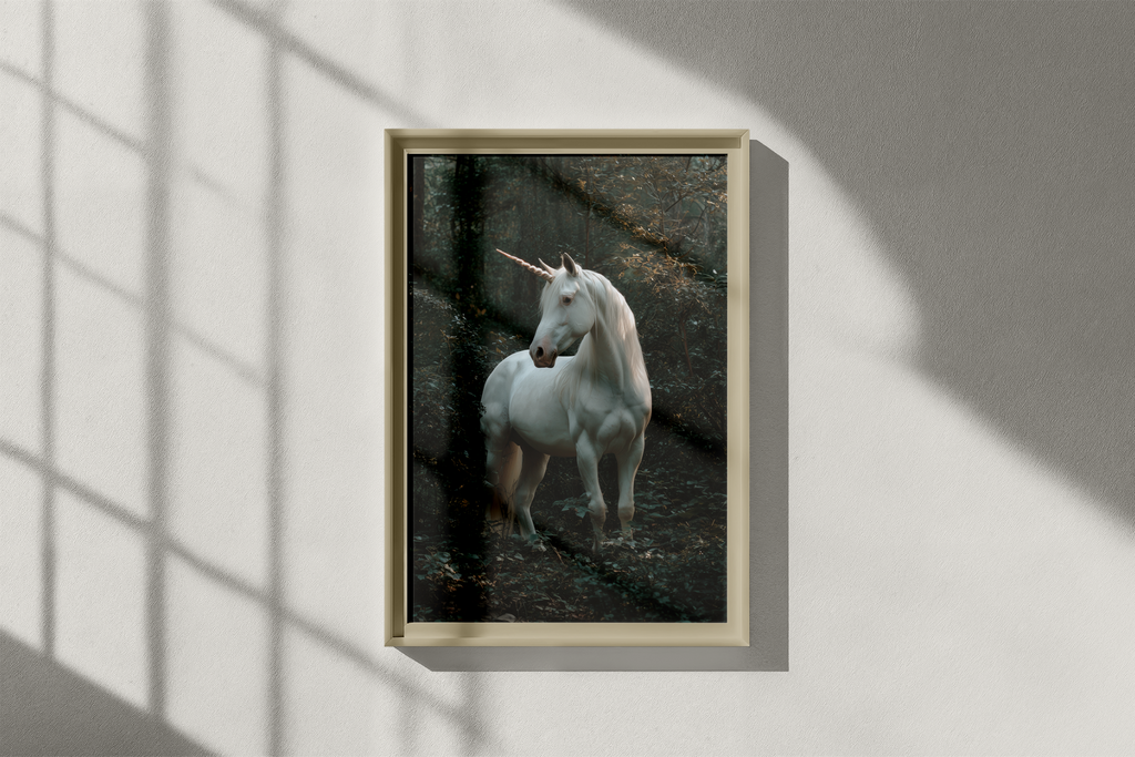 Framed picture of a unicorn on a wall with shadows from a window.