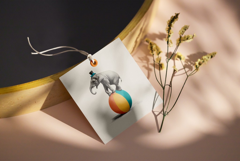 Gift card with elephant and ball illustration on textured surface with flowers.