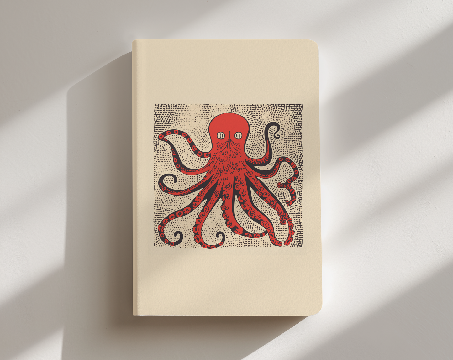 Beige notebook with a red octopus illustration on a white background